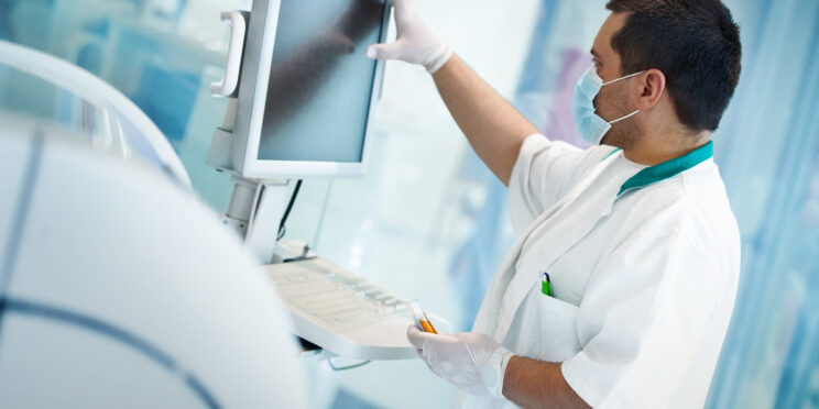 Técnico de laboratorio ingresando datos en el analizador de sangre.
